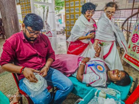 Blood donors being greeted with flower by Mahanam Sevak Sangha members